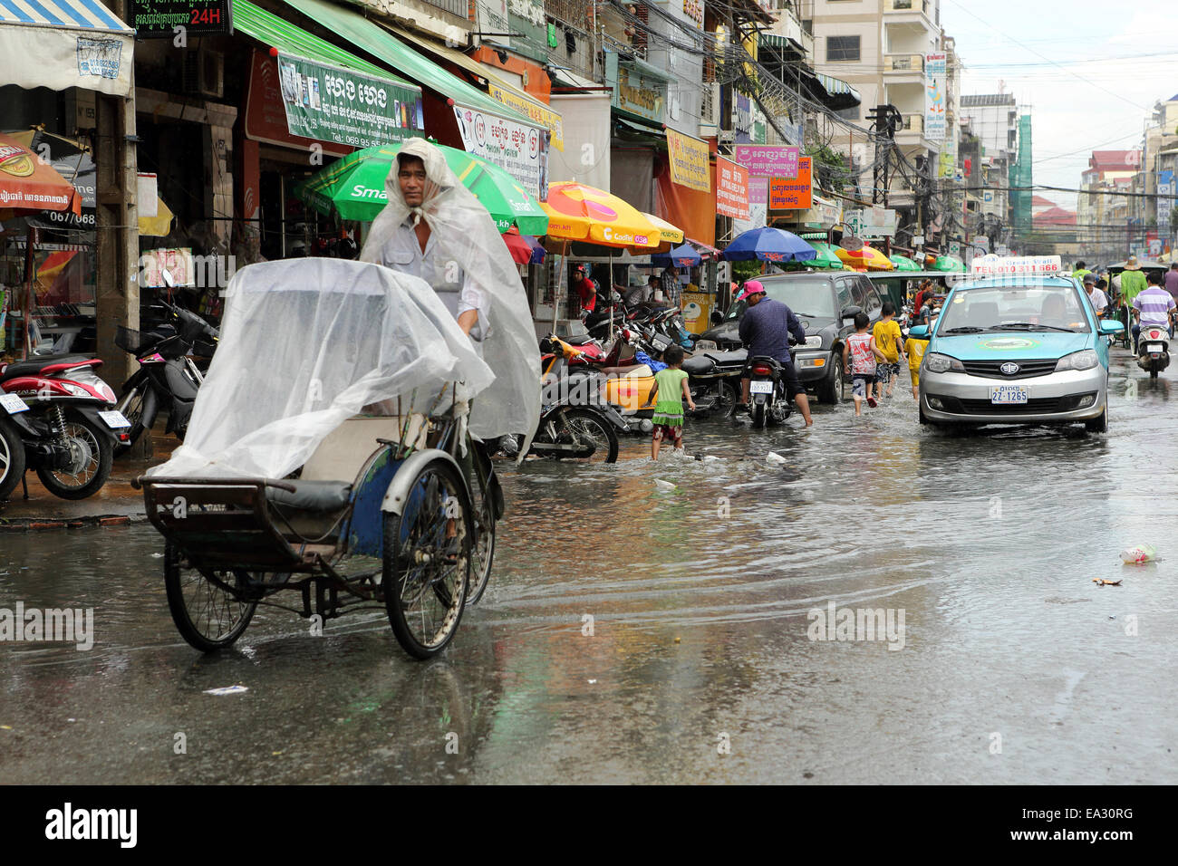 Verkehr auf einer aufgeweichten Straße während der Monsunzeit in Phnom Penh, Kambodscha, Asien, Südostasien, Indochina Stockfoto