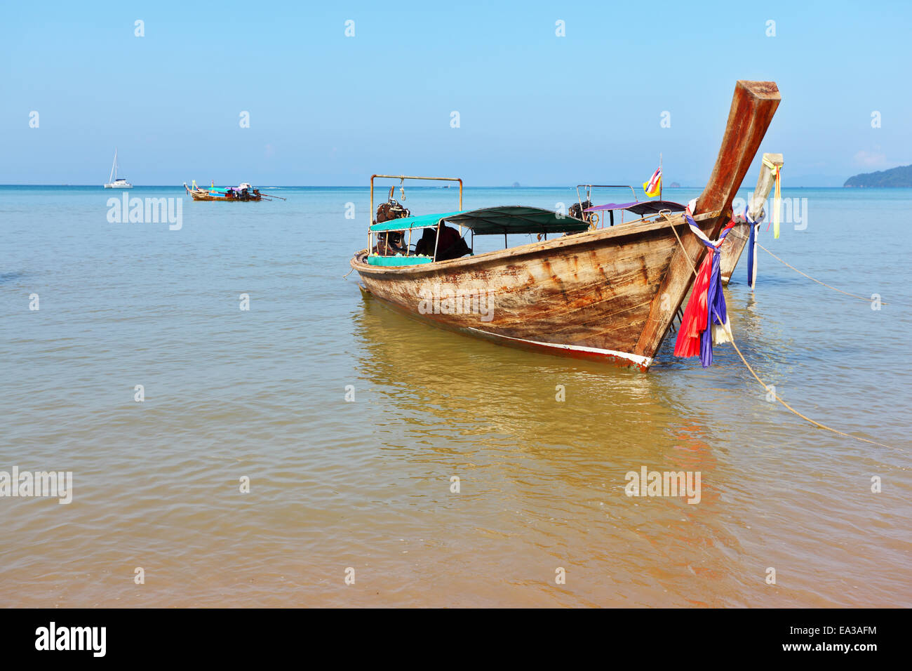 Ein Longtail-Boot in orange Strandsand Stockfoto