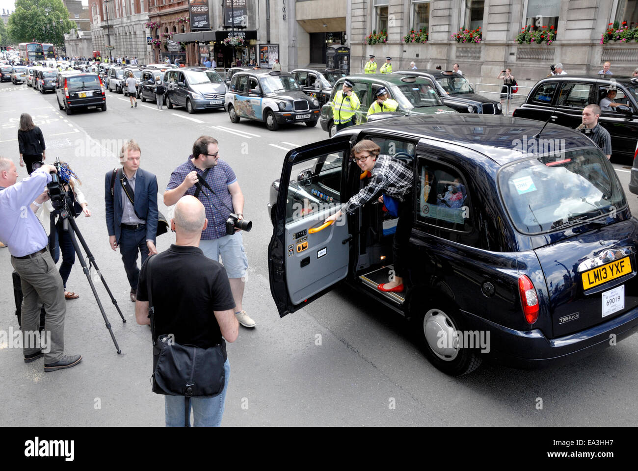 London, England, Vereinigtes Königreich. Frau aus einem schwarzen Taxi in Whitehall - TV-Film-crew Stockfoto