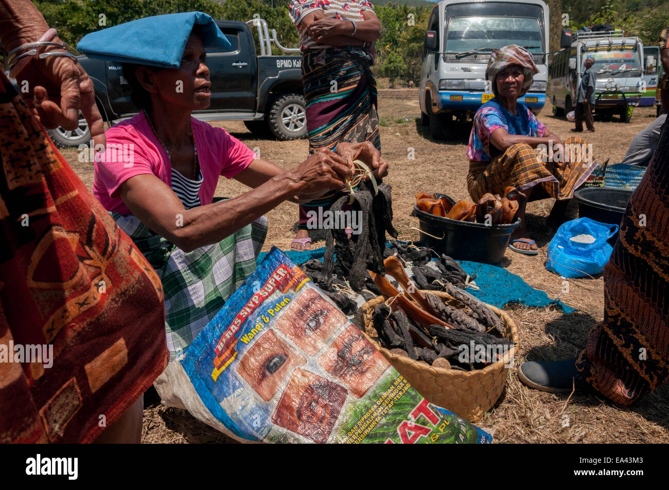 Frauen aus Lamalera nehmen mit ihrem getrockneten Walfleisch an einem Tauschmarkt in Lembata Island, Indonesien, Teil. Stockfoto