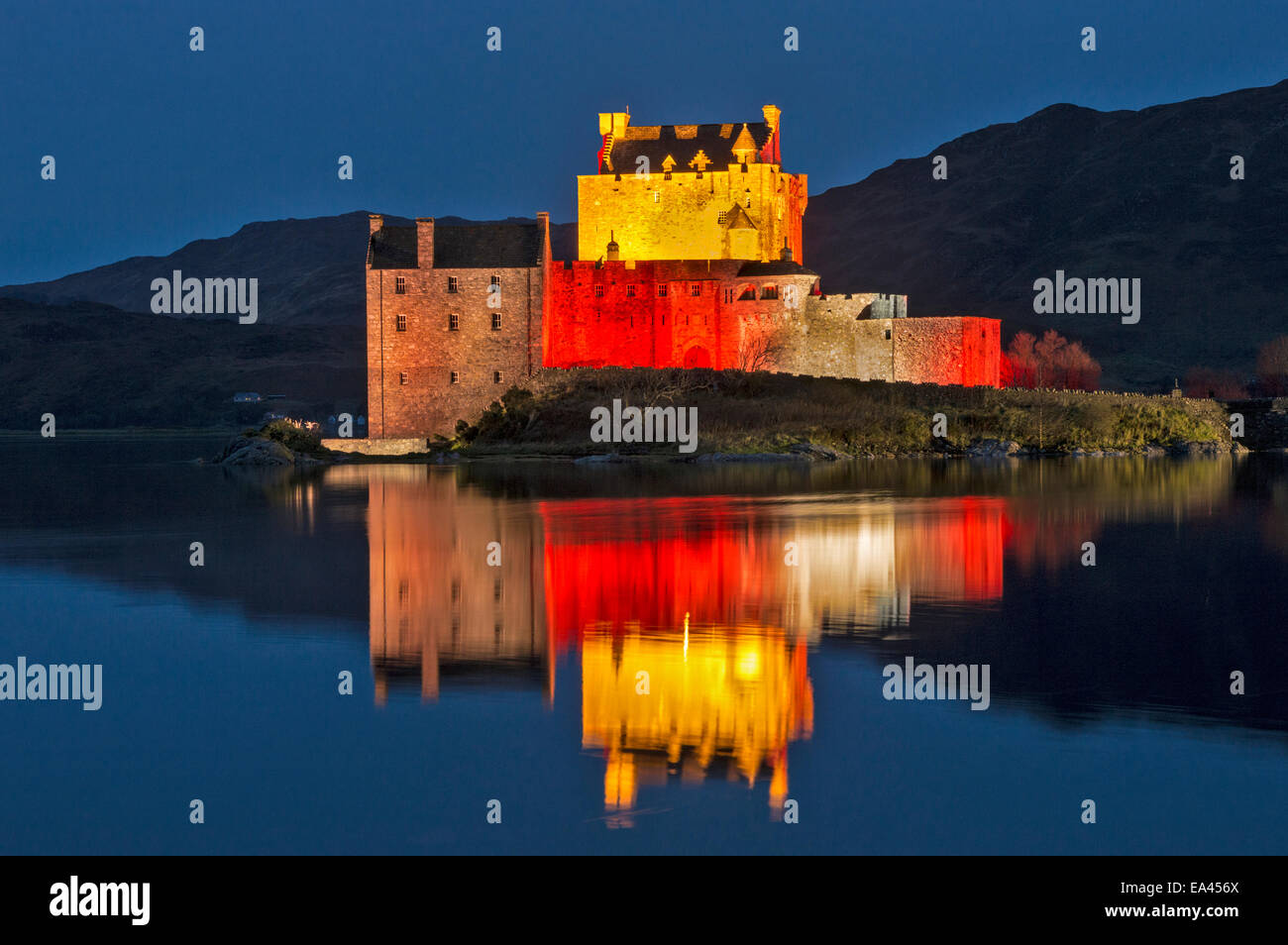 EILEAN DONAN CASTLE MIT ROTEN LICHTER AM ABEND SPIEGELT SICH AUF SEE LOCH NESS FÜR ARMISTICE DAY 11. NOVEMBER 2014 Stockfoto