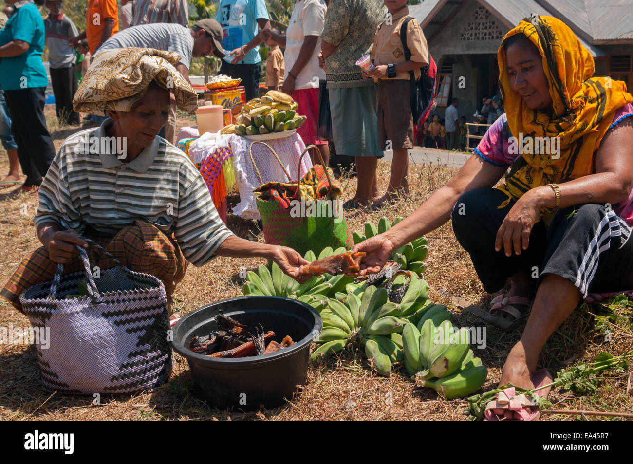 Frauen, die Gemüse und Obst mit getrocknetem Walfleisch auf einem Tauschmarkt in Lembata Island, Indonesien, handeln. Stockfoto