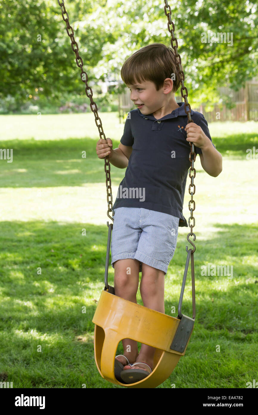 Kleiner Junge spielt im Garten Schaukel, USA Stockfoto