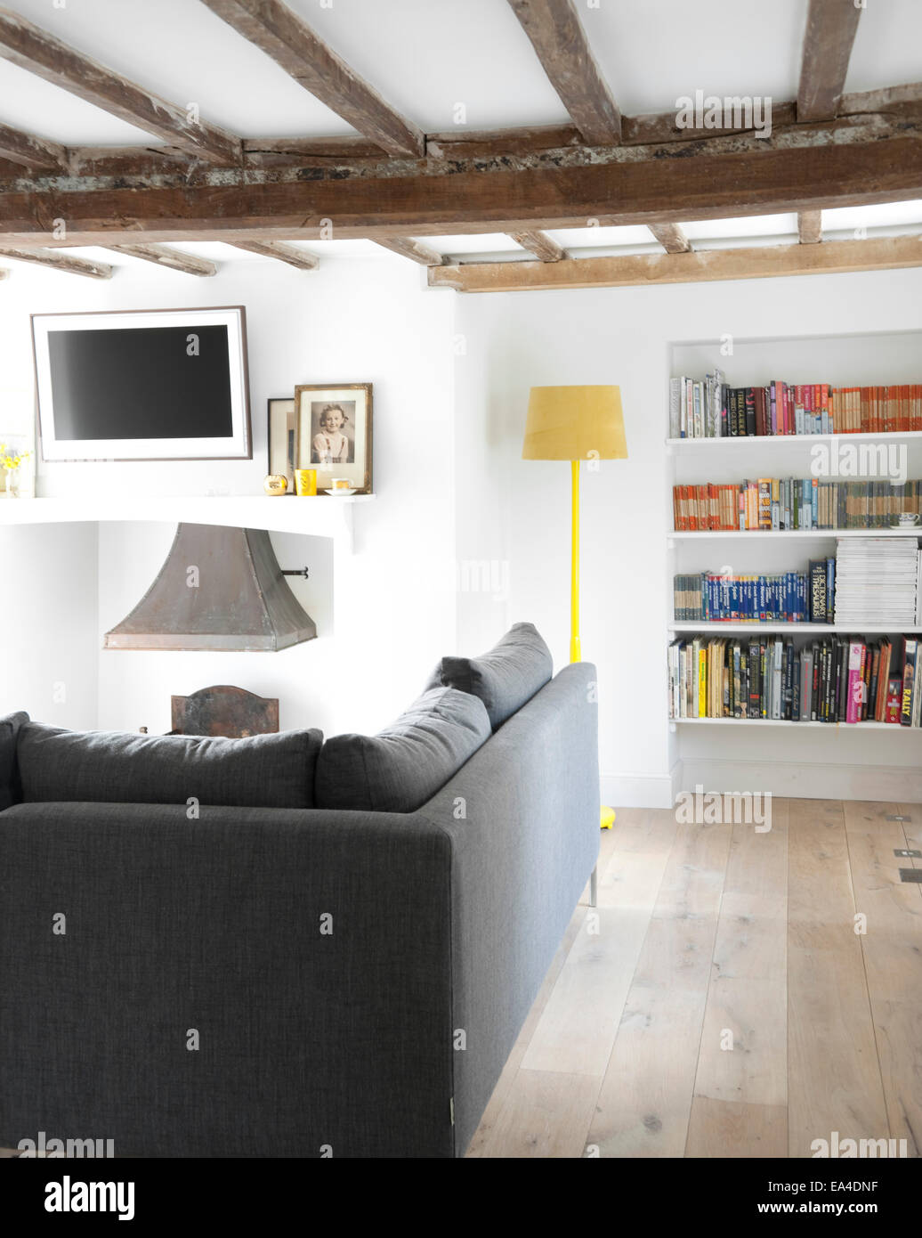 Wohnzimmer mit Bücherregal und grau Sofa im Landhaus Interieur, UK. Stockfoto