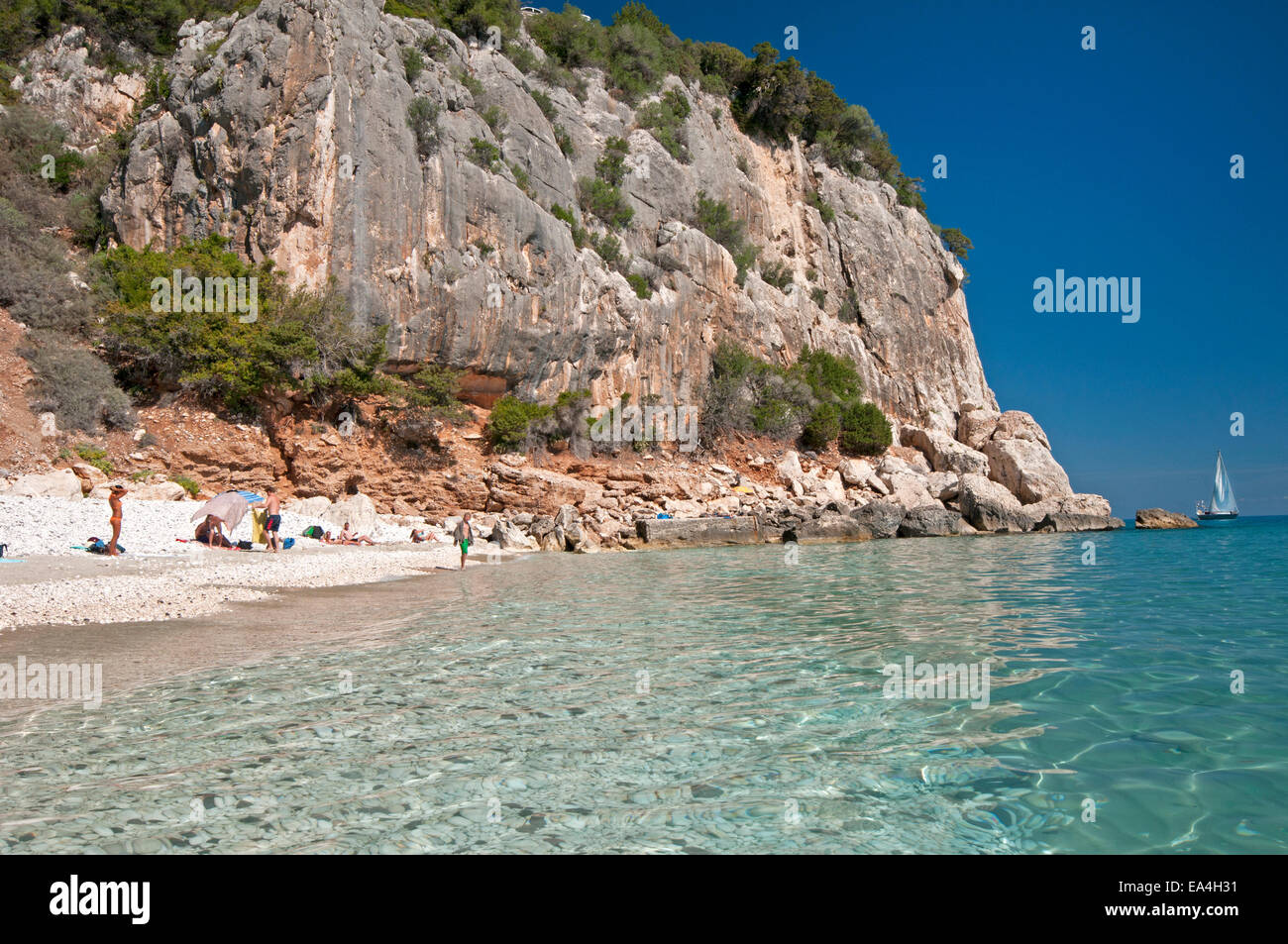 Touristen und Segelboot am Strand von Cala Fuili, Dorgali, Cala Gonone, Orosei Golf Sardinien, Italien Stockfoto