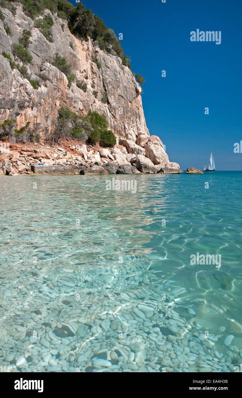 Touristen und Segelboot am Strand von Cala Fuili, Dorgali, Cala Gonone, Orosei Golf Sardinien, Italien Stockfoto