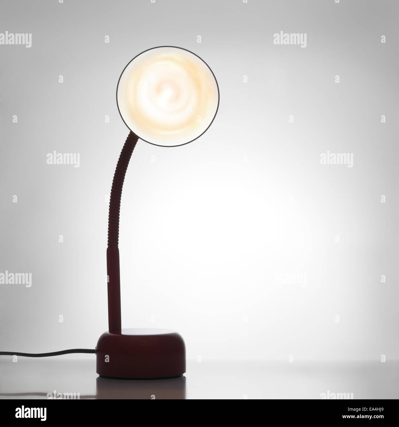 Schreibtischlampe eingeschaltet. Gegenlicht Hintergrund Stockfoto