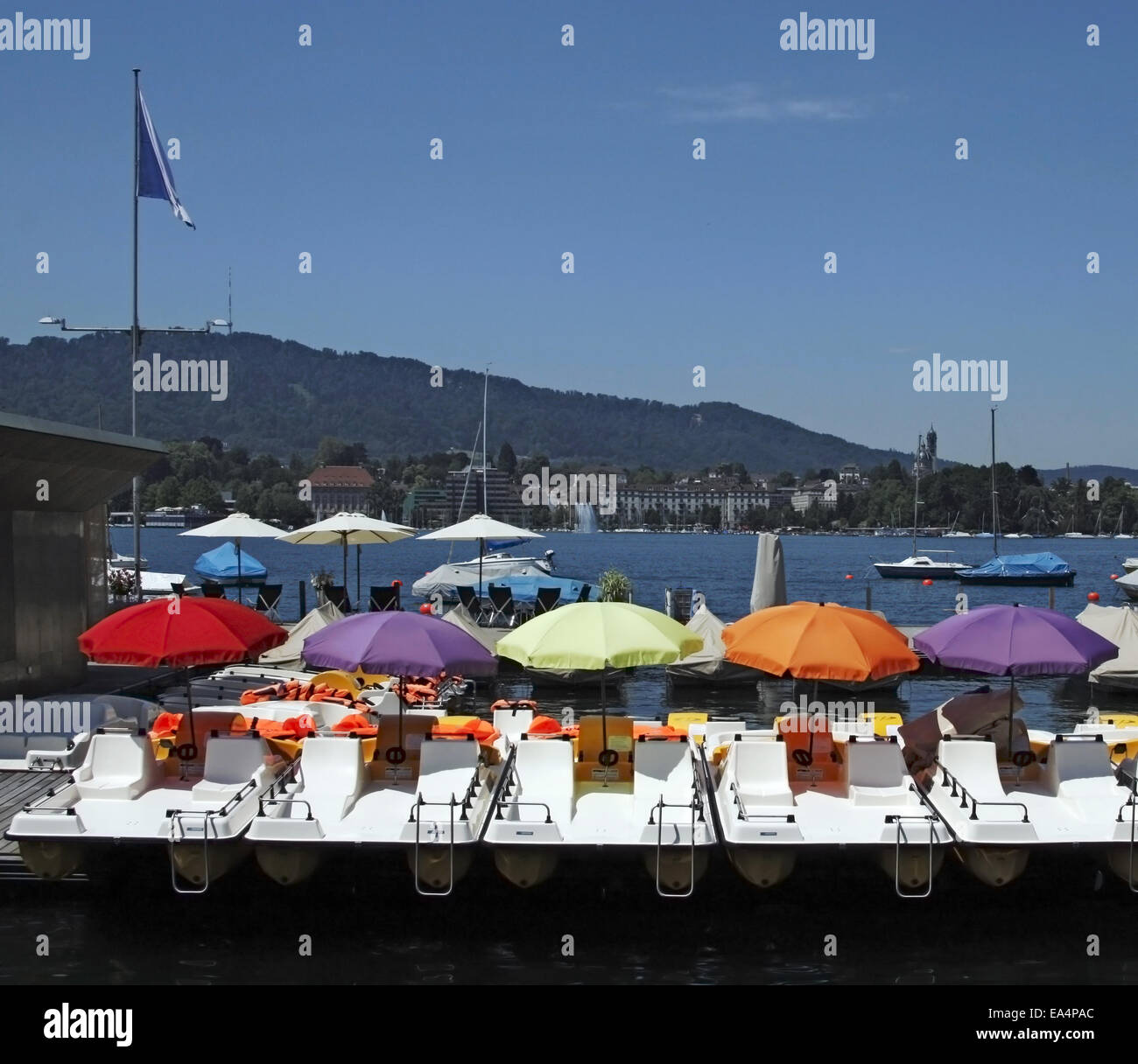 Paddelboote mit Sonnenschirmen in verschiedenen Farben am Zürichsee, Schweiz Stockfoto