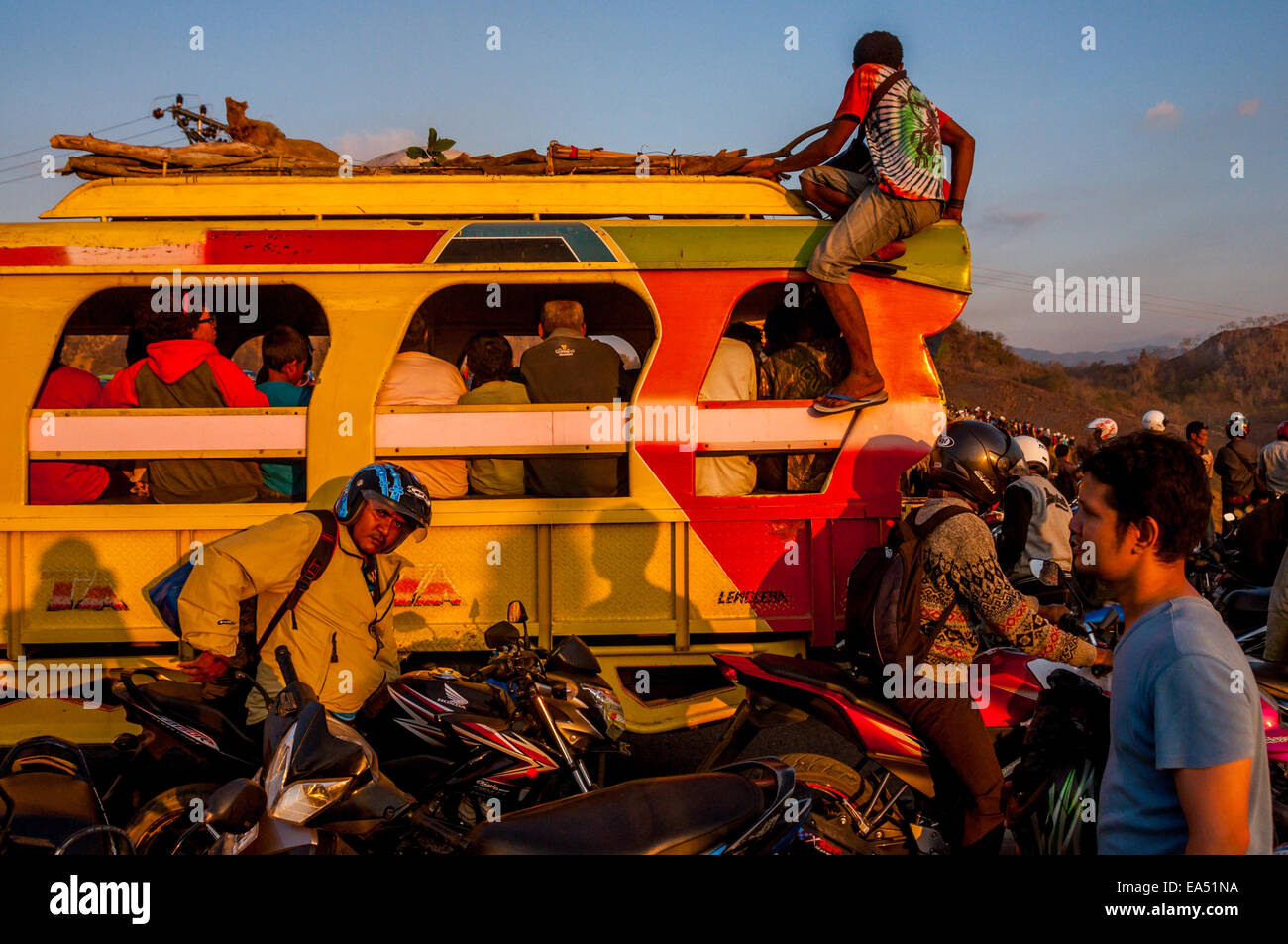 Ein voll beladener Minibus, der nach einem Motocross-Wettbewerb in Waijarang, Nubatukan, Lembata, East Nusa Tenggara, Indonesien, durch eine überfüllte Straße fährt. Stockfoto