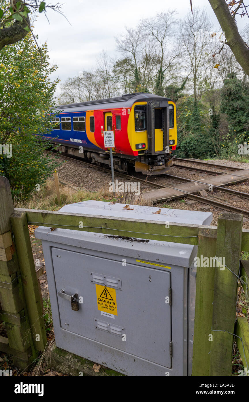 East Midlands Zug überfahren einen öffentlichen Fußweg mit Warnschild und eine graue elektrische Abzweigdose. Stockfoto
