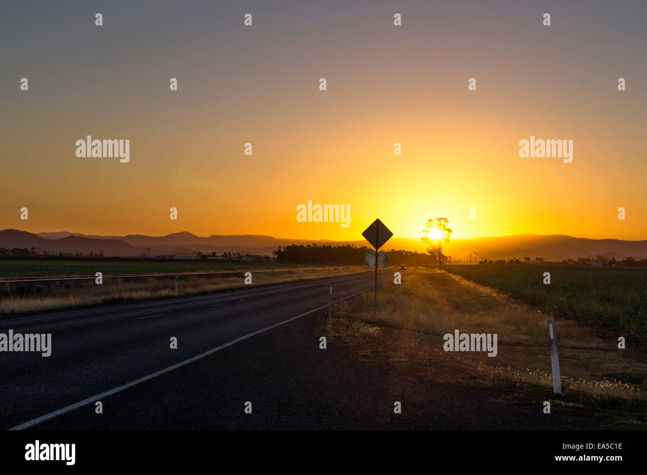 Australien, Queensland, Straße mit Bergkette bei Sonnenaufgang Stockfoto