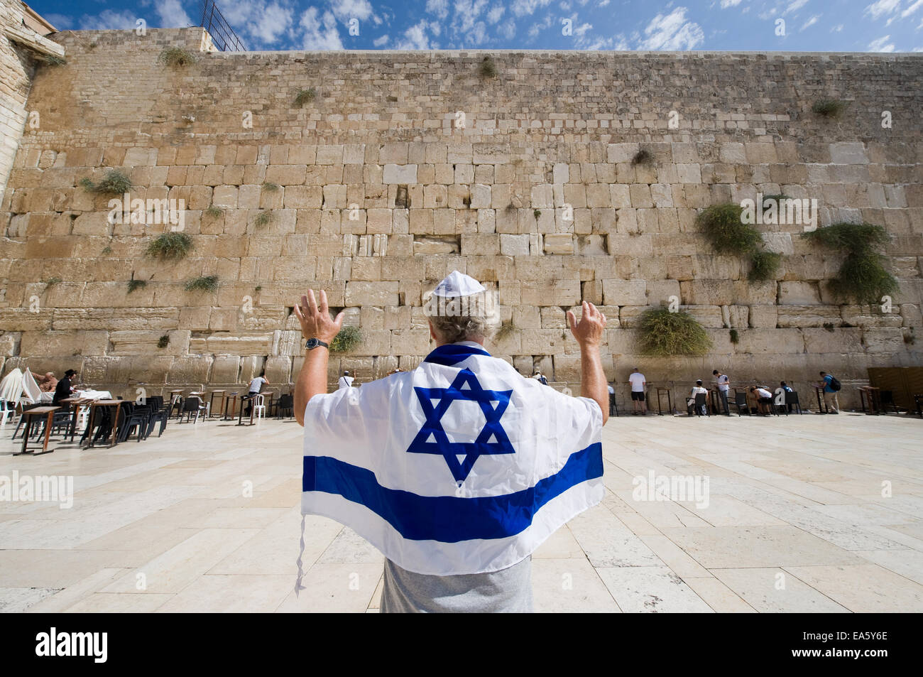 Ein Mann mit einer israelischen Flagge und seine Arme vor der westlichen Klagemauer in der Altstadt von Jerusalem Stockfoto