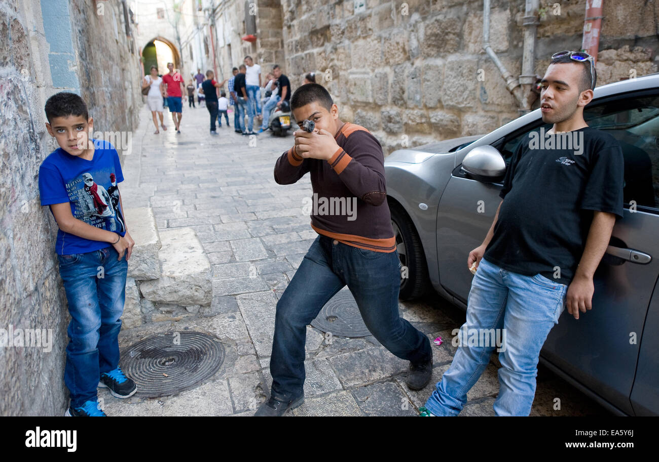 Drei junge muslimische Jugendliche spielen "Kriegsspiele" auf den Straßen im muslimischen Viertel in Jerusalem. Stockfoto