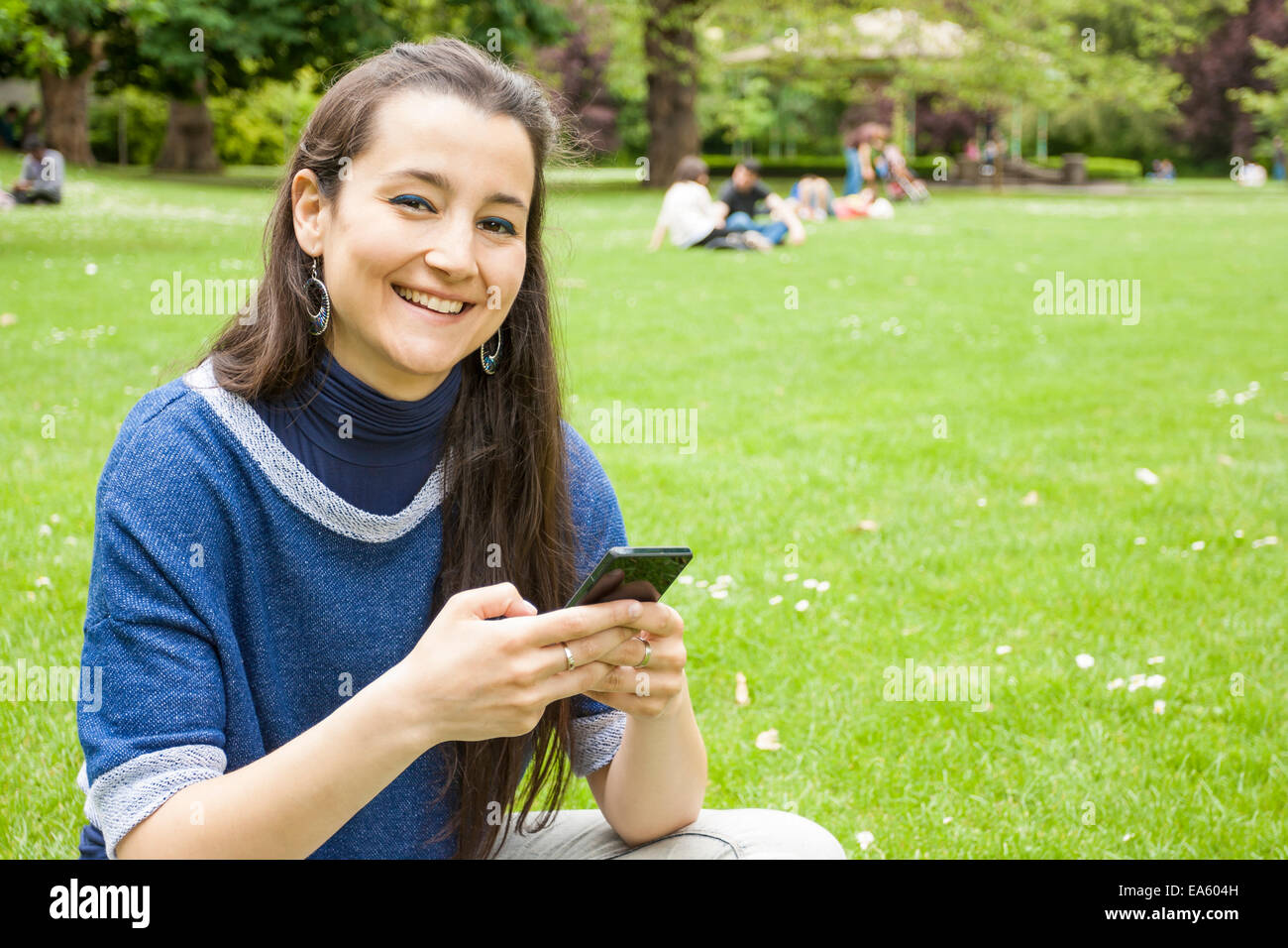 Schöne Frau mit Smartphone in Stephens Green Park Stockfoto