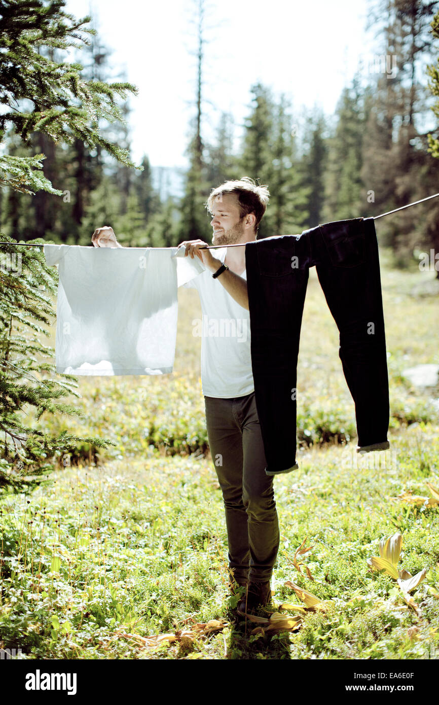 Mann Aufhängen von Wäsche auf Wiese Stockfoto