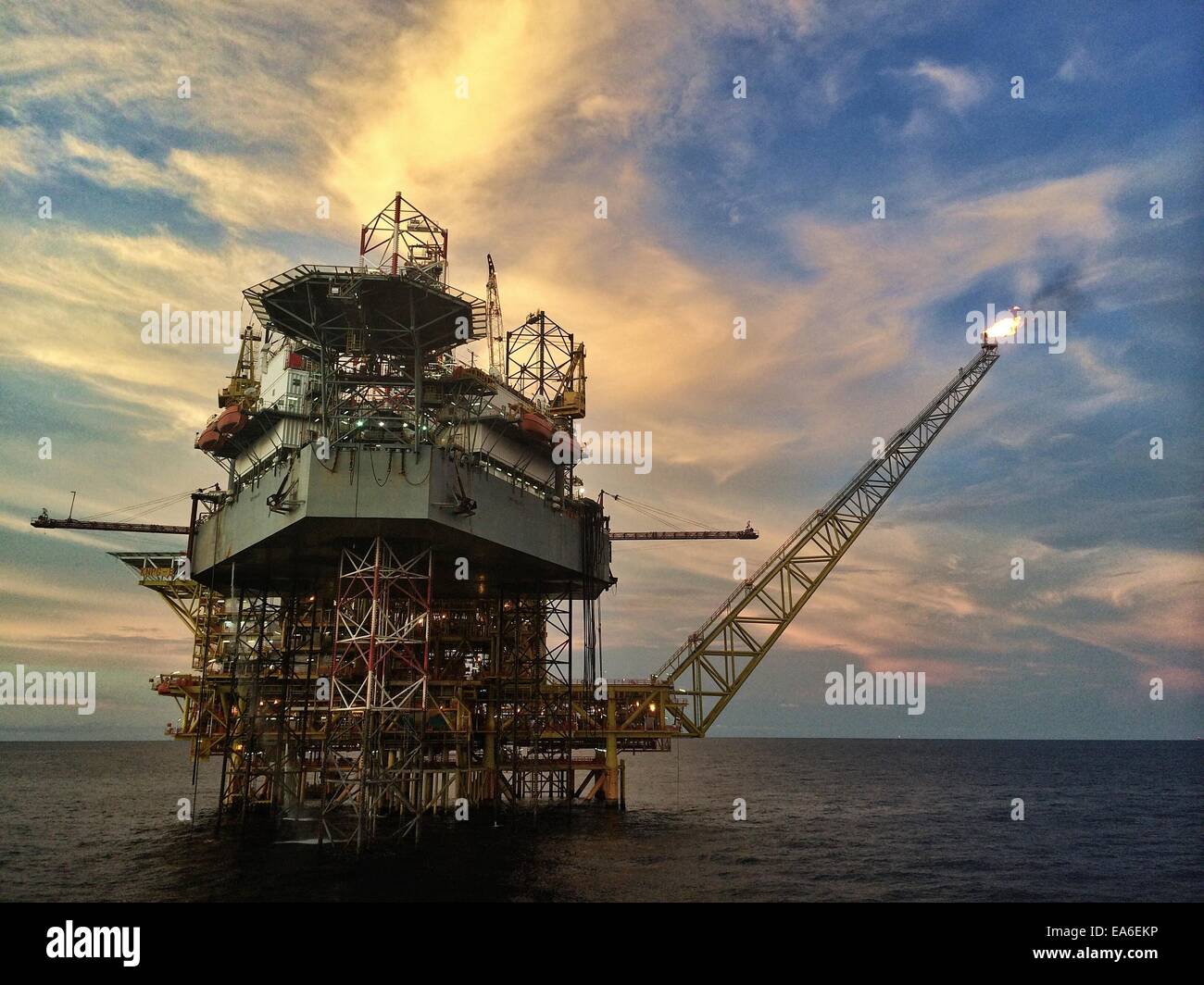Offshore-Öl- und Gas-Plattform mit Öl Jack Up Rig bei Sonnenuntergang Stockfoto