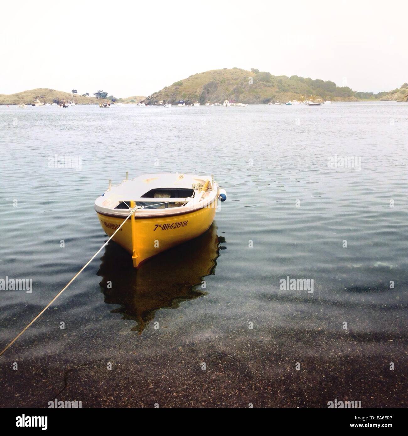 Spanien, Cadaques, Boot verankert in ruhigem Wasser Stockfoto
