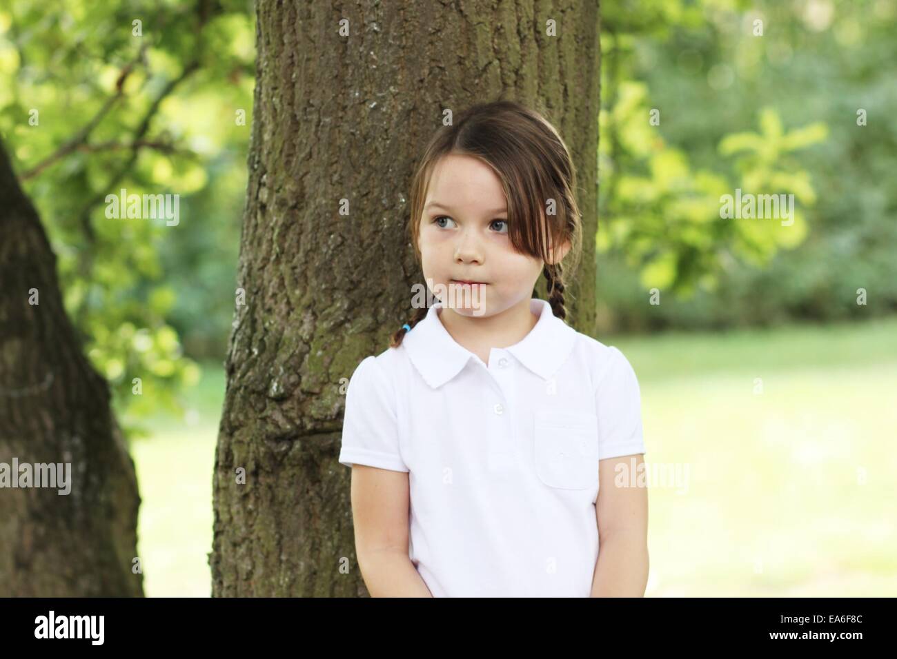 Porträt eines Mädchens durch Baum stehen Stockfoto