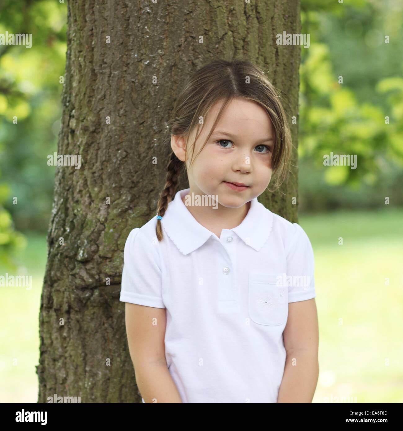 Porträt eines Mädchens durch Baum stehen Stockfoto
