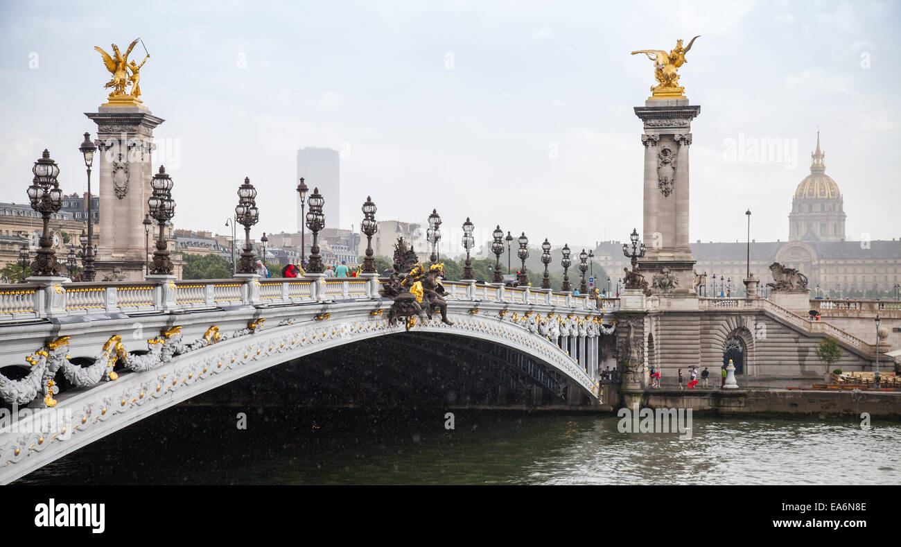 Paris, Frankreich - 7. August 2014: Menschen zu Fuß auf der Pont Alexandre III (Brücke Alexander III) in einem verregneten Sommertag Stockfoto