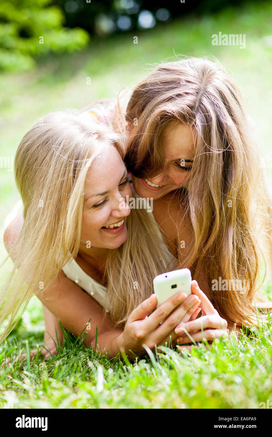 Mädchen im Park mit Mobiltelefonen Stockfoto