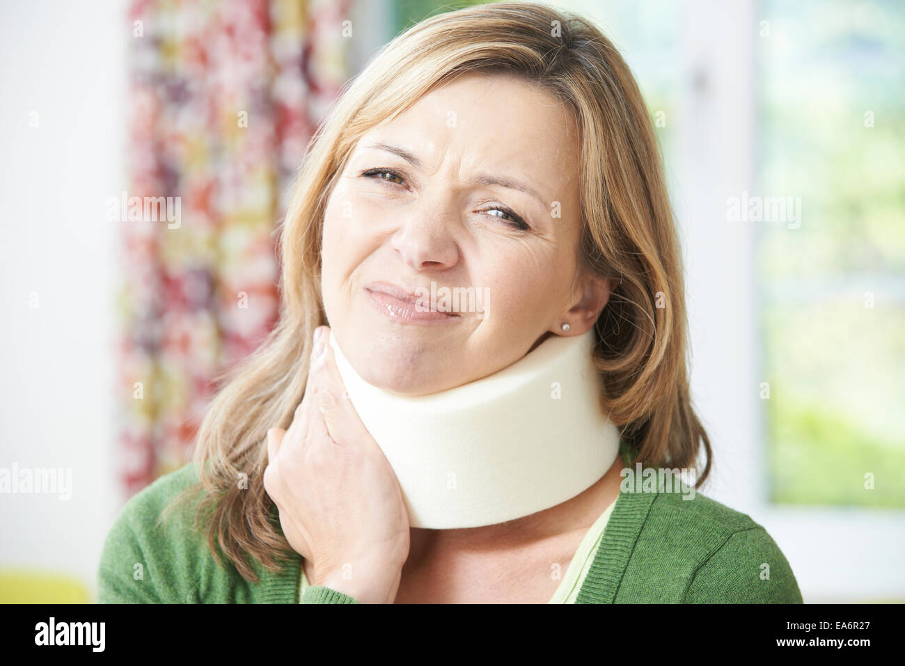 Frau trägt chirurgische Kragen In Schmerzen Stockfoto