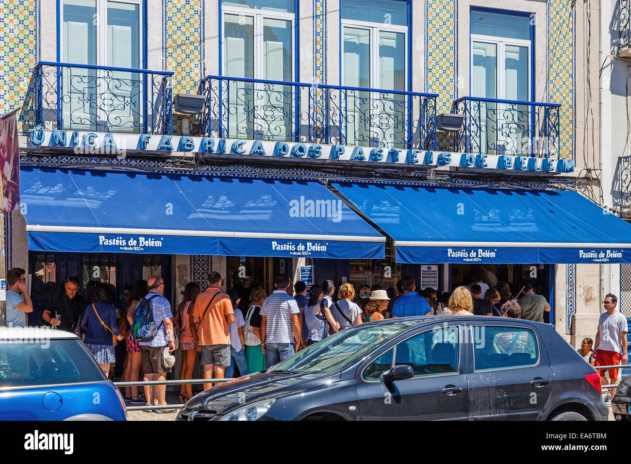 Der berühmte Pasteis de Belém – Ei Puddingtörtchen - Konditorei in Lissabon. Kunden warten auf der Straße, da der Laden immer voll ist. Stockfoto