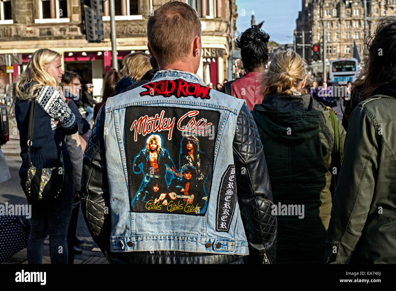 Die Rückansicht eines jungen Mannes mit einer schwarzen Leder und Denim Jacke mit der Heavy-Metal-Bands Motley Crue und Skid Row. Stockfoto