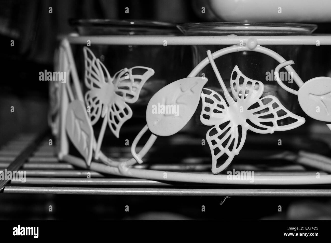 Die Seite des Drahtes Kerzenhalter mit Glas Kerze Gläser innen mit Schmetterling und Blatt-Dekor. Stockfoto