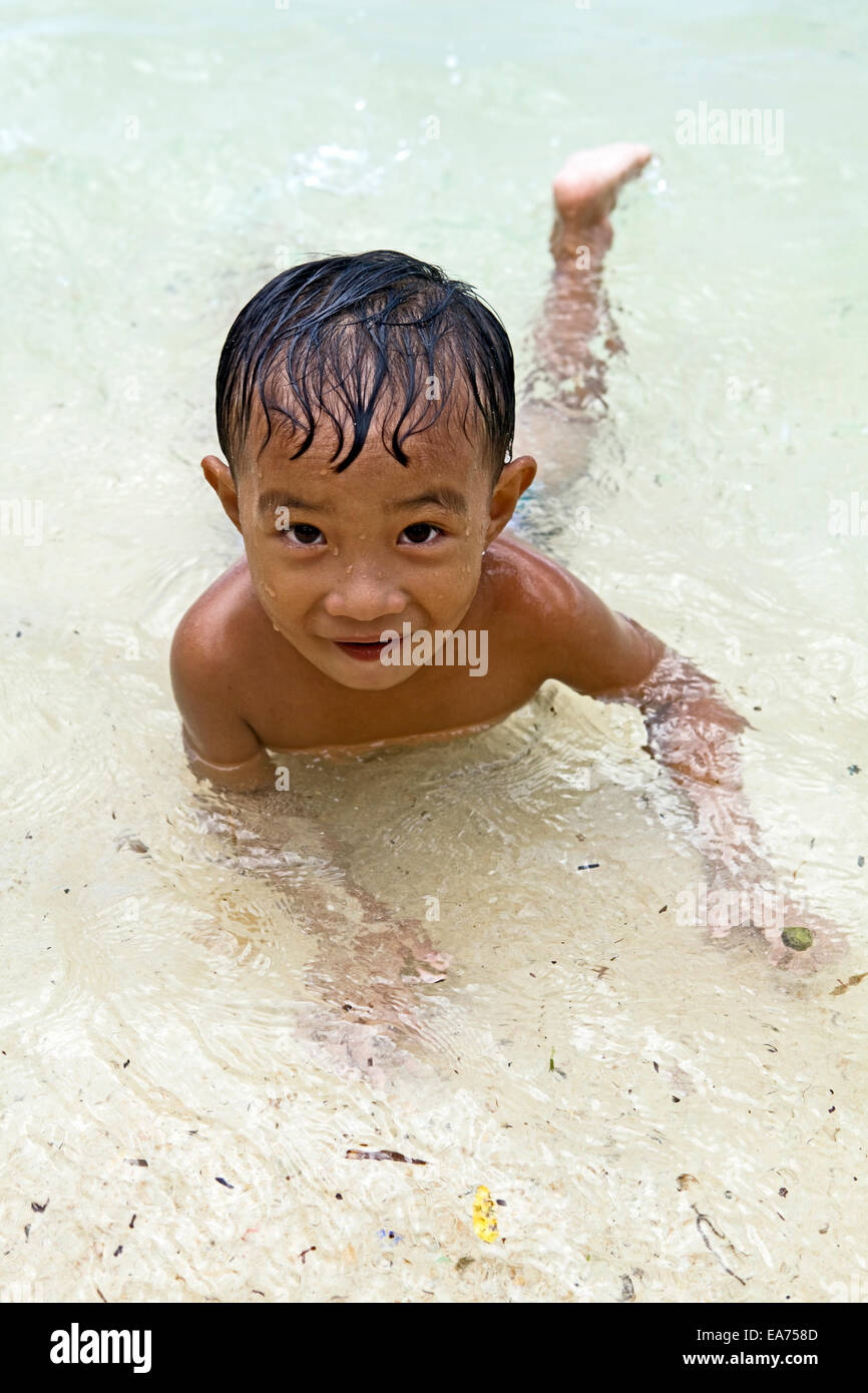Ein Filipino junge etwa drei Jahre alt spielt in das seichte Wasser am Strand auf Guimaras Island, Philippinen... Stockfoto