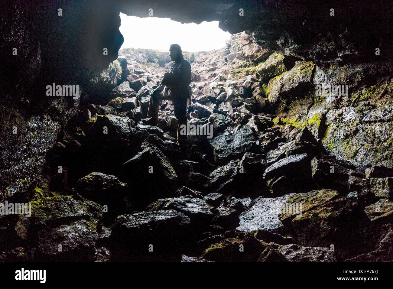 Mann am Eingang zur Larendi Höhle, einen alten Lavatunnel durch geschmolzene Lava gebildet. Stockfoto