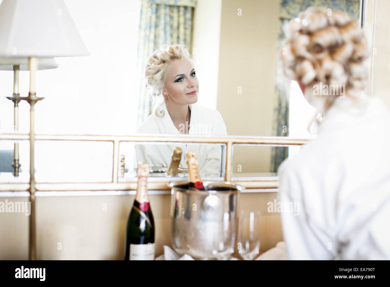 Frau im Spiegel betrachtet Stockfoto