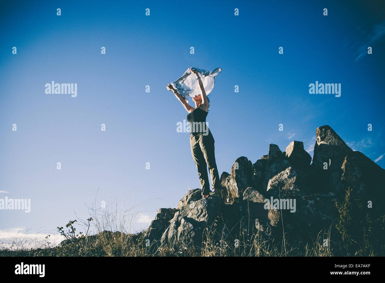 Frau stehend auf Felsen und Erhöhung der Schal Stockfoto