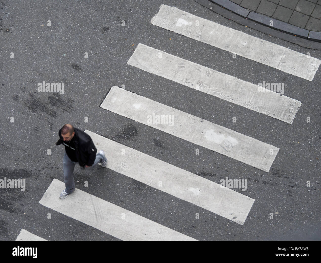 Luftaufnahme von einer Person, die einen Zebrastreifen überqueren Stockfoto