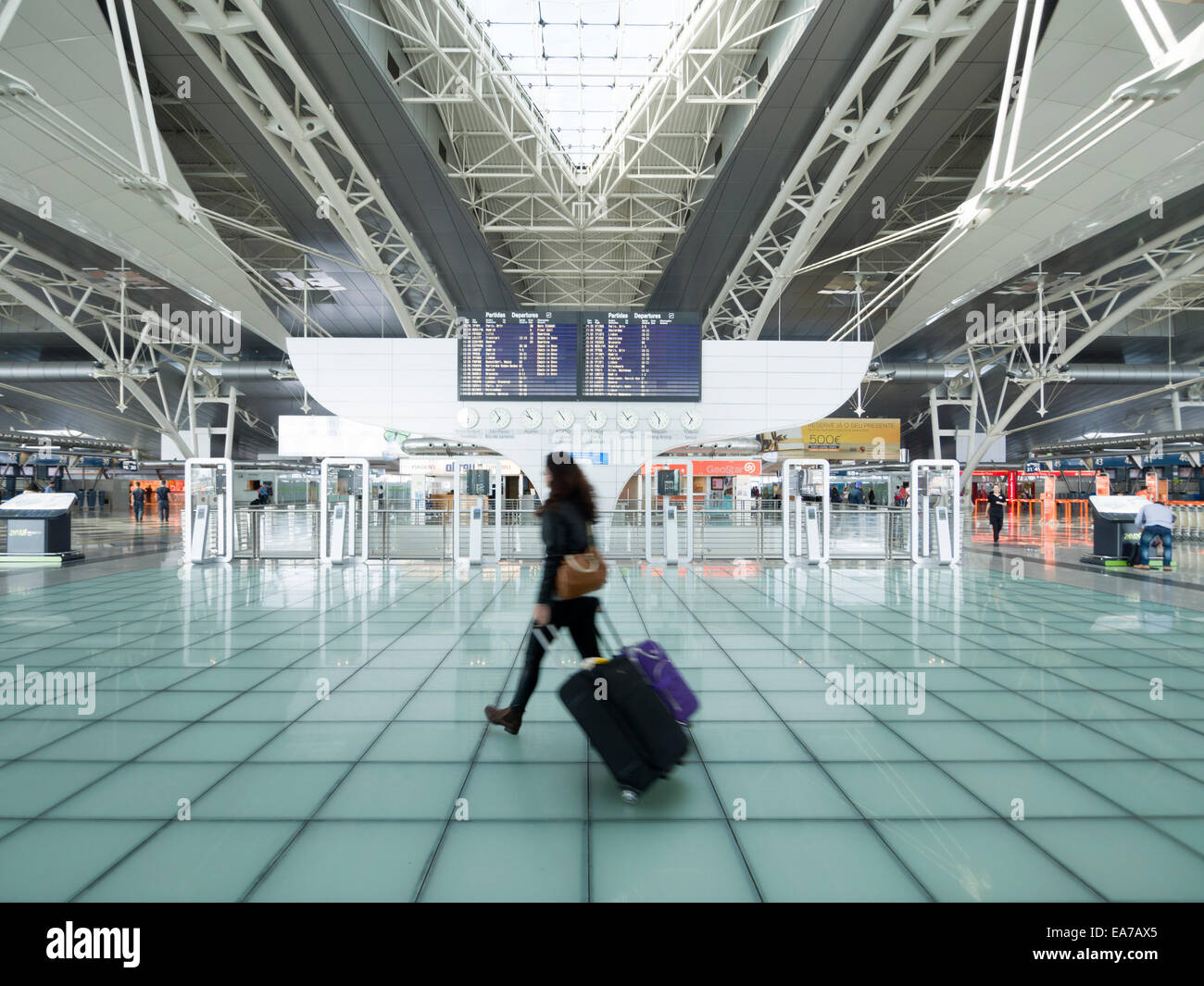 Passagier mit Koffern vorbei Zeitplan Flugtafel am Sá Carneiro Flughafen terminal in Porto, Portugal Stockfoto