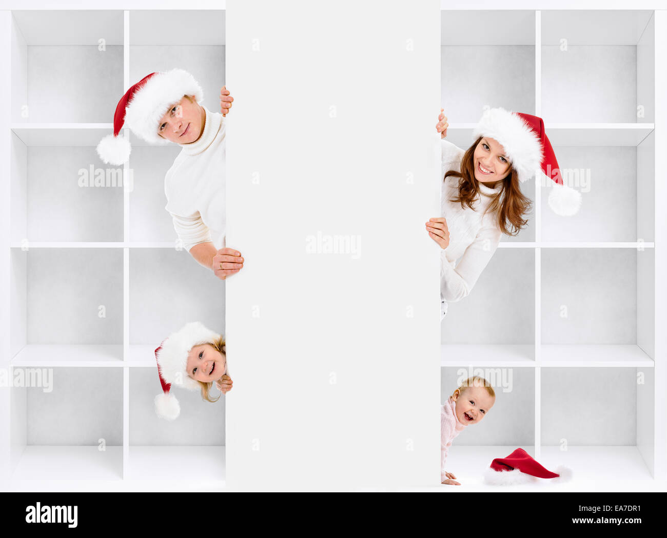 Weihnachten-Familie in Santas Hüte mit Regal Stockfoto