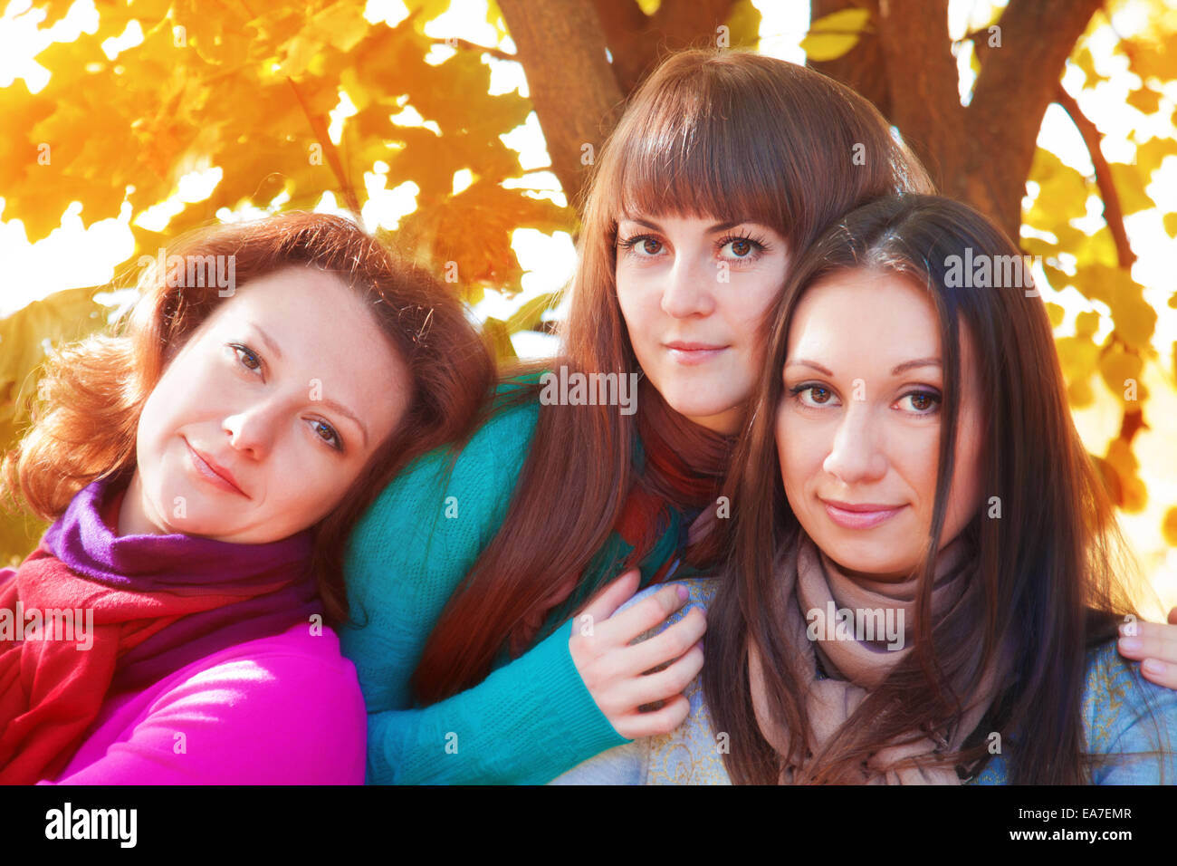 Drei Frauen auf dem Hintergrund der Blätter im Herbst Stockfoto
