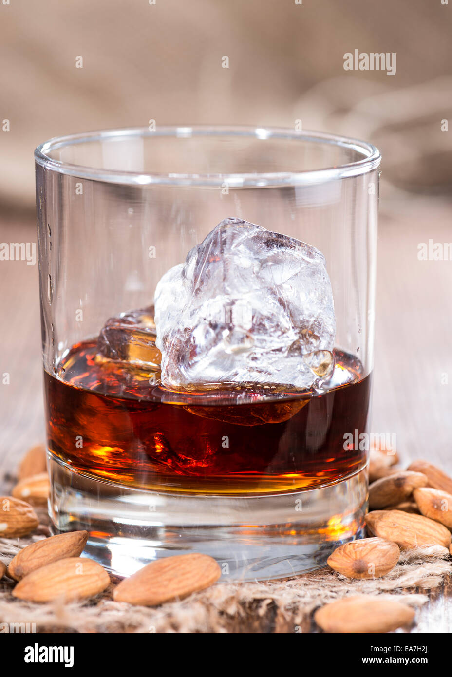 Glas mit Amaretto und Eiswürfeln auf dunklem Hintergrund mit einigen  Mandeln Stockfotografie - Alamy