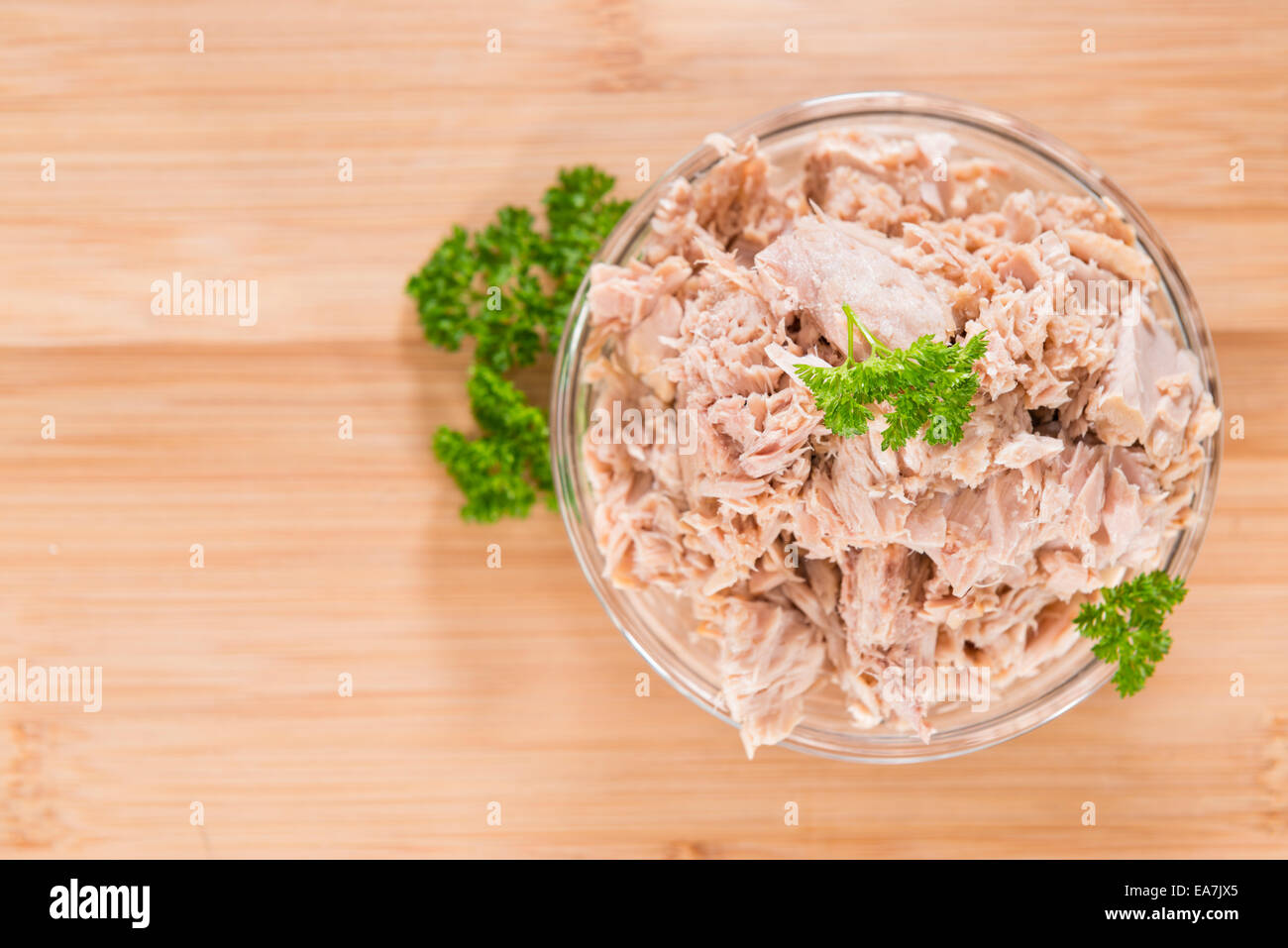 Dosen Thunfisch mit frischer Petersilie (detaillierte Nahaufnahme gedreht) auf hölzernen Hintergrund Stockfoto