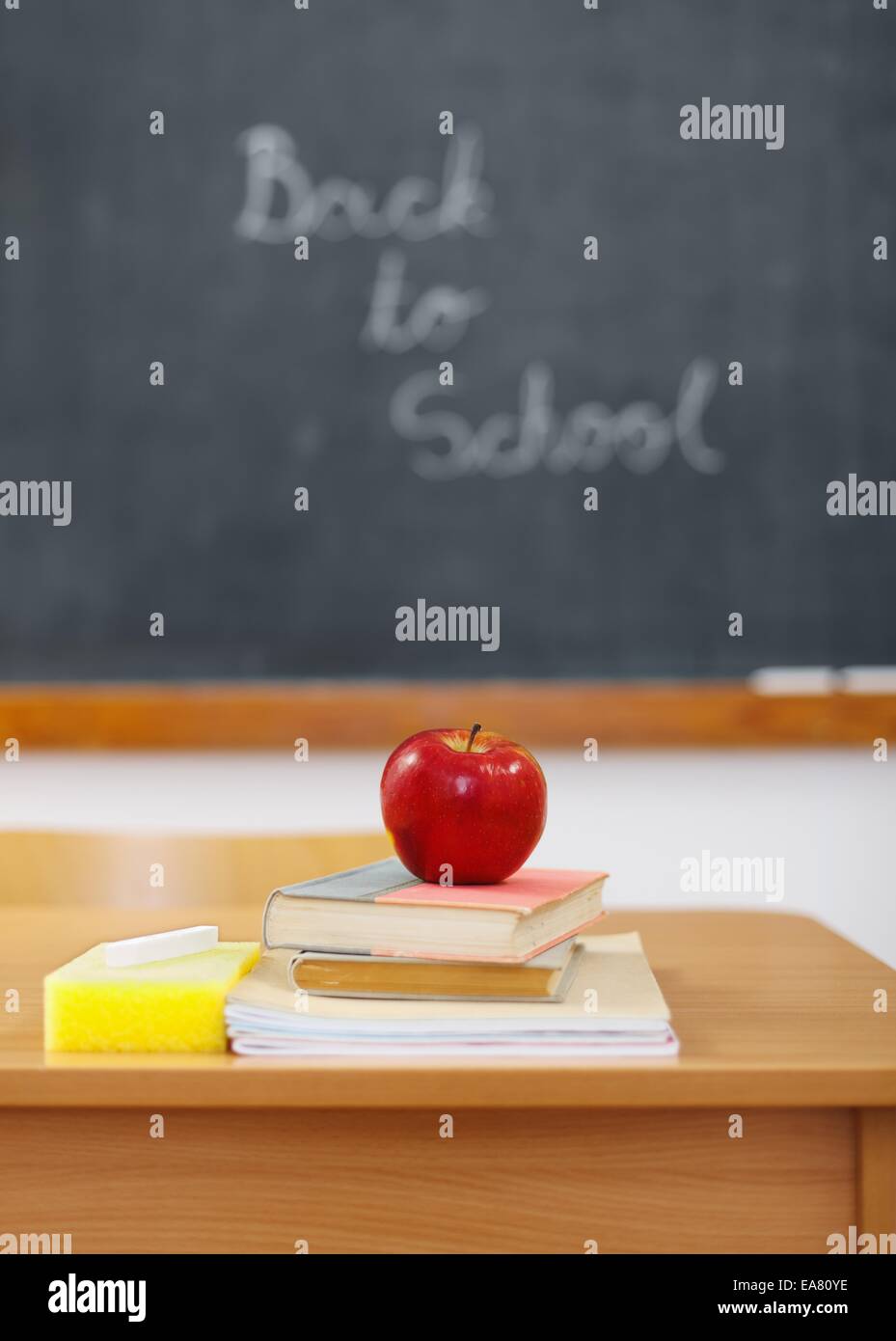 Zurück zu Schule auf Tafel und roter Apfel auf Bücher vor (Schwerpunkt Apfel) Stockfoto