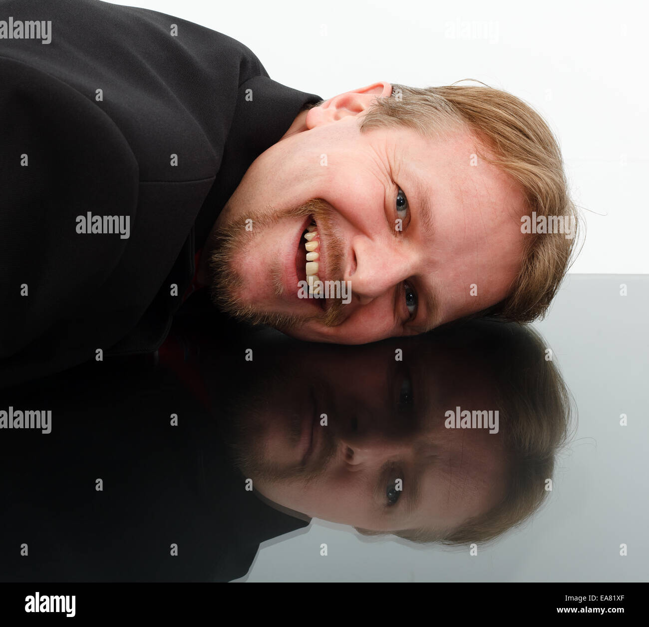 Mann zeigt entgegengesetzte Verhalten im Spiegel: Freude und Trauer Stockfoto
