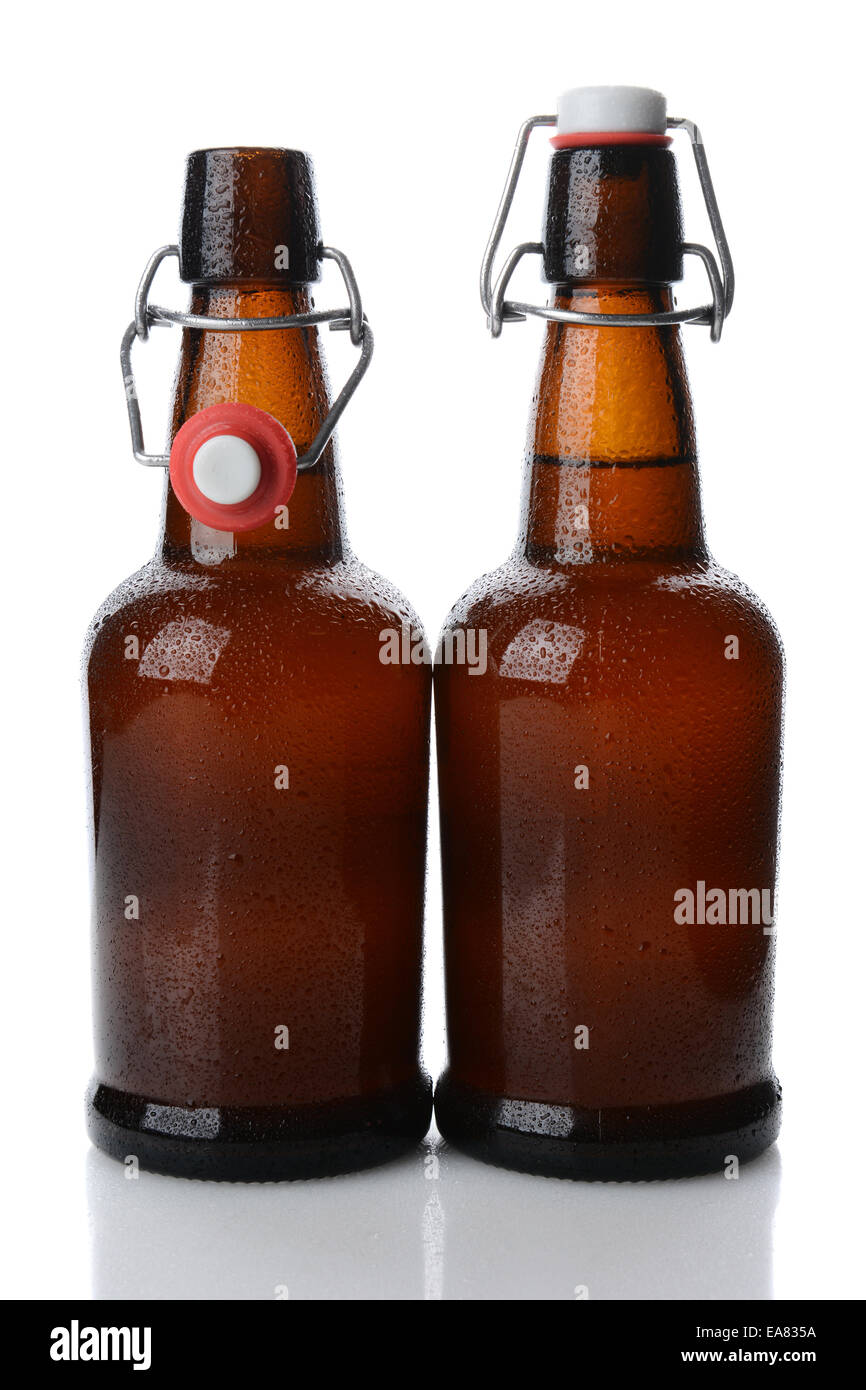 Nahaufnahme von zwei kalte Schaukel oberen braunen Bierflaschen mit Kondenswasser bedeckt, eine Flasche geöffnet ist. Hochformat auf weiß mit re Stockfoto