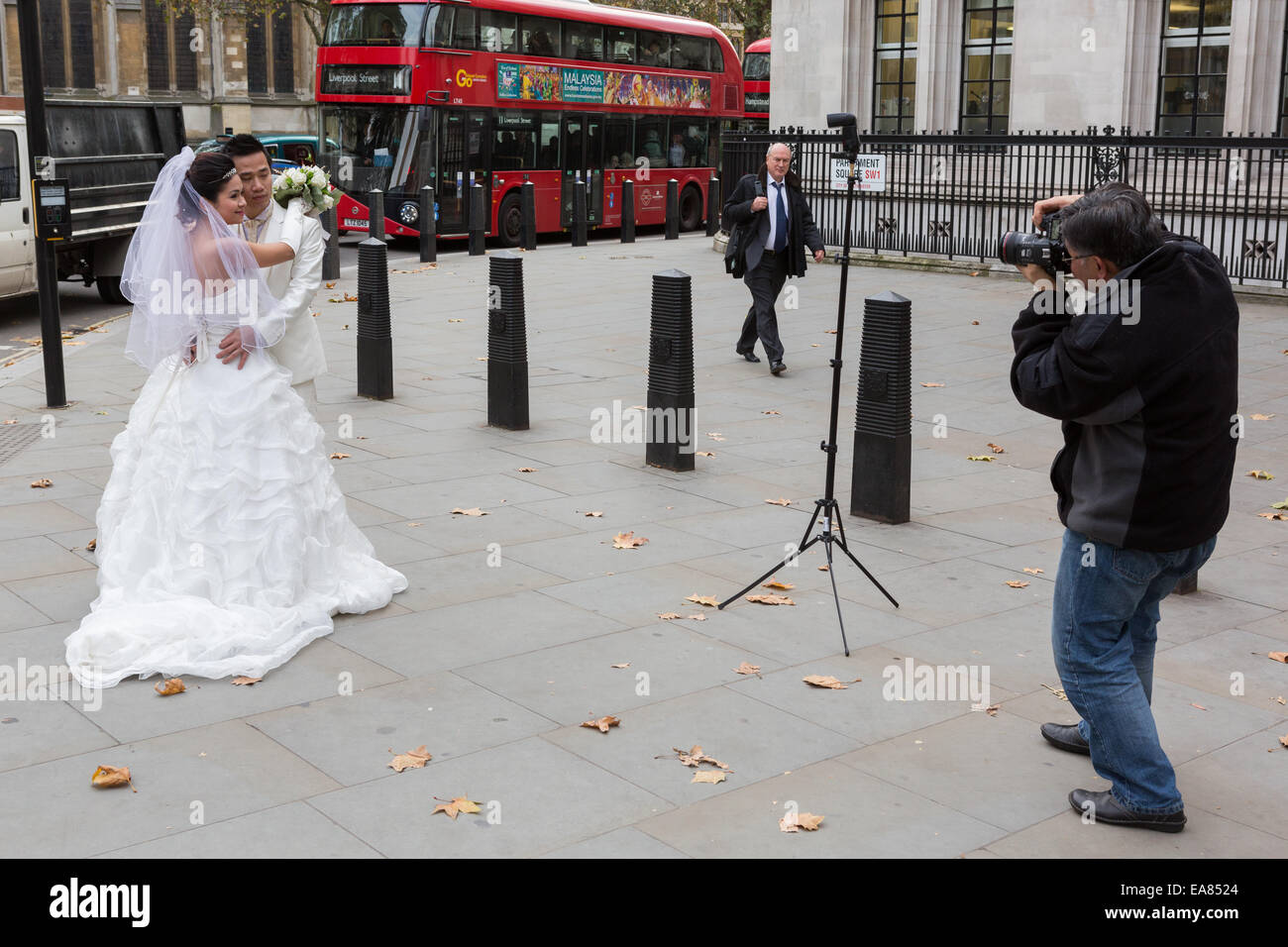 Ein chinesisches Ehepaar haben Hochzeitsfotos genommen außerhalb der Westminster Abbey in London, England, UK Stockfoto