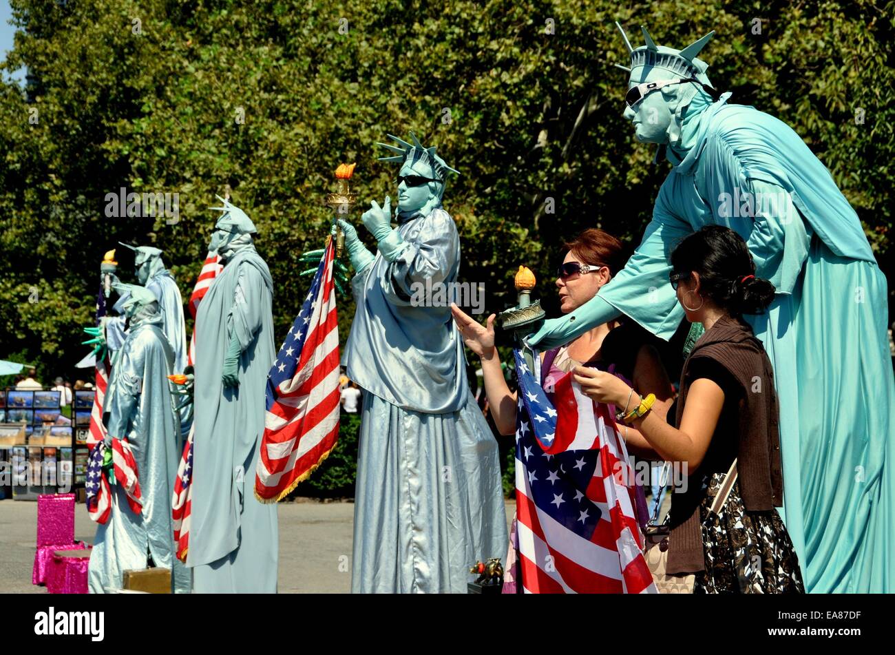 NYC: Touristen posieren für Fotos mit Tipp-suchenden lebendigen Statue of Liberty Mimen im Battery Park Stockfoto