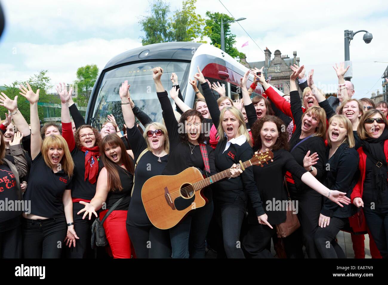 Mitglied des singen in der Stadt-Gruppe spielen in den offiziellen Start von Edinburgh Tram. Edinburgh Straßenbahnen Passagier Stockfoto