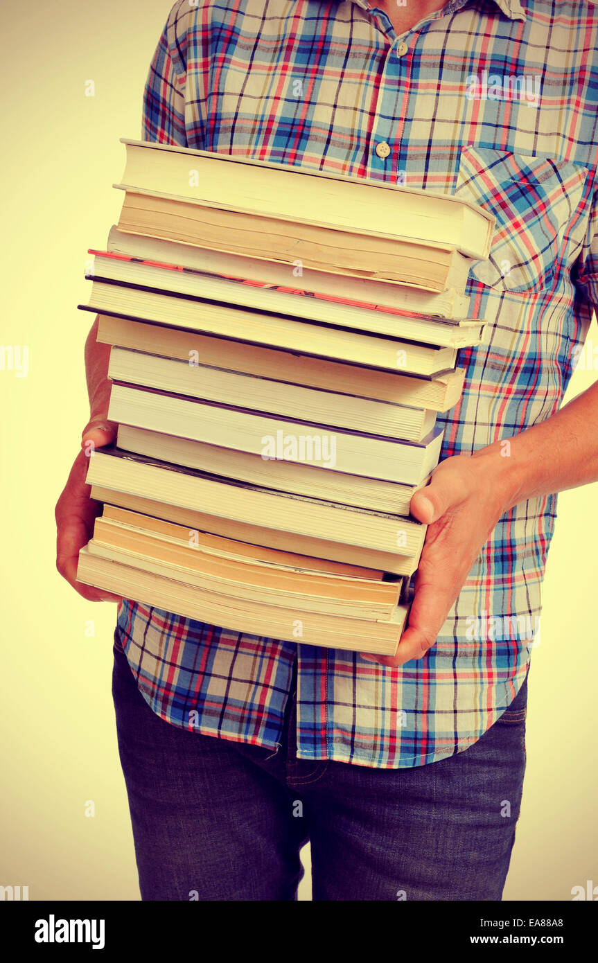 junge Mann trägt einen Stapel Bücher mit einem Filtereffekt Stockfoto