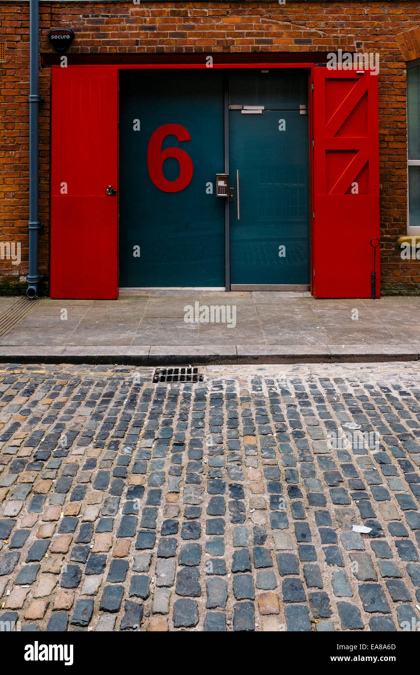 Eine große Zahl 6 schmückt eine blaue Tür in einem Teil des viktorianischen Mühle in Manchesters Ancoats Bezirk. Stockfoto