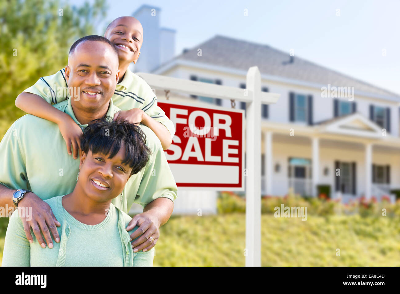 Happy African American Family vor Verkauf Immobilien Zeichen und Haus. Stockfoto