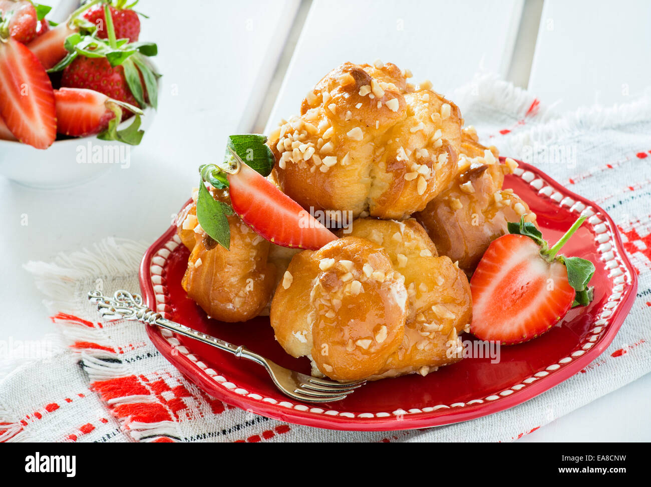 Windbeutel mit Nüssen und Erdbeeren auf hellem Hintergrund Stockfoto