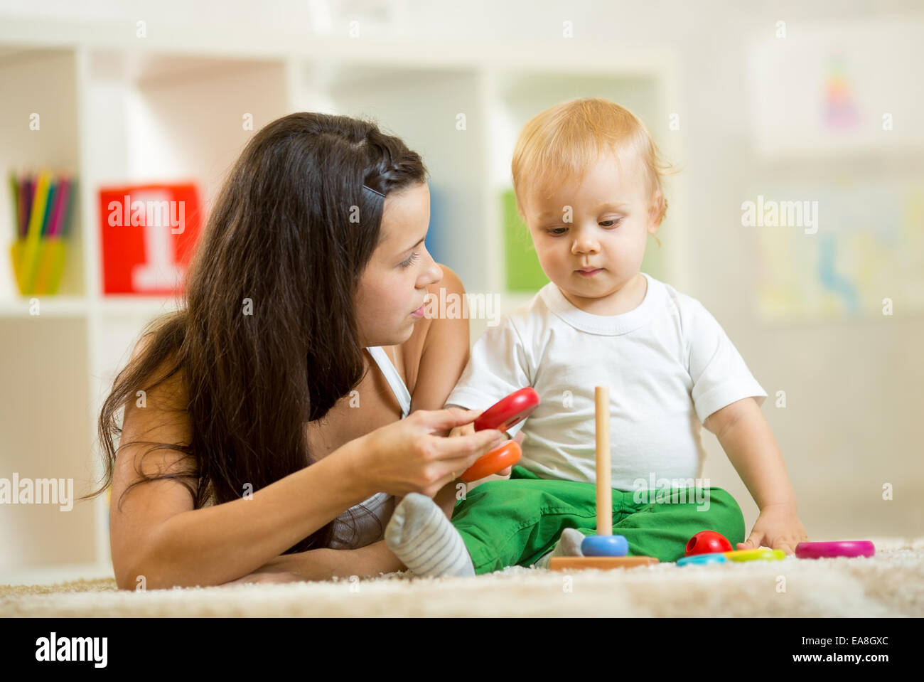 süße Mutter und Baby Boy spielen zusammen innen zu Hause Stockfoto